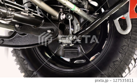 Car suspension part. Close up of a rear car suspension and exhaust system. such as coil springs link arms axle housing and performance exhaust. For auto engineering or car suspension part industry use 127535811