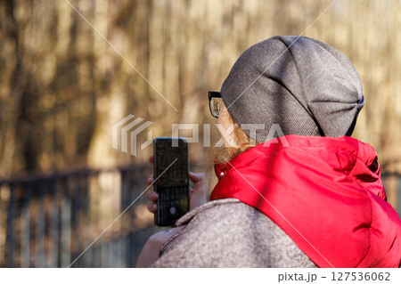 Capturing natures essence while enjoying a moment outdoors in a cozy jacket and beanie during autumn Capturing natures essence while enjoying a moment outdoors in a cozy jacket and beanie during autumn 127536062
