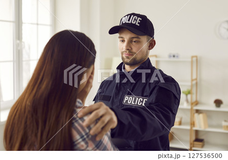 Woman crime victim and a policeman putting his hand on her shoulder to support her. 127536500