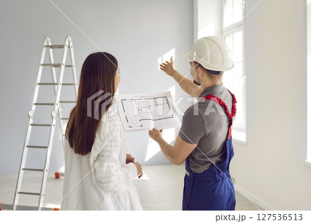 Builder and woman discussing renovation process in apartment Builder and woman discussing renovation process in apartment 127536513