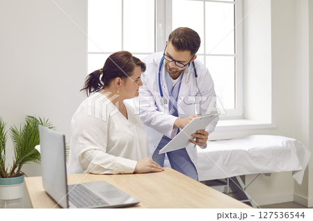 Overweight woman having consultation at doctor's office during medical exam in clinic. Overweight woman having consultation at doctor's office during medical exam in clinic. 127536544