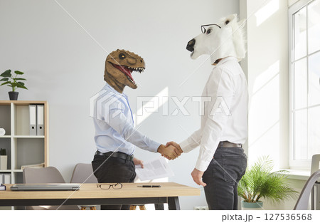Two colleagues in animal head masks handshaking after meeting Two colleagues in animal head masks handshaking after meeting 127536568