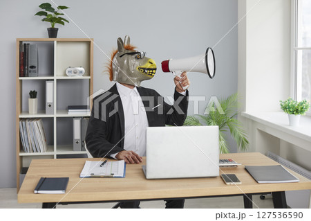 Man wearing donkey animal mask sitting in the office and shouting in megaphone. Man wearing donkey animal mask sitting in the office and shouting in megaphone. 127536590