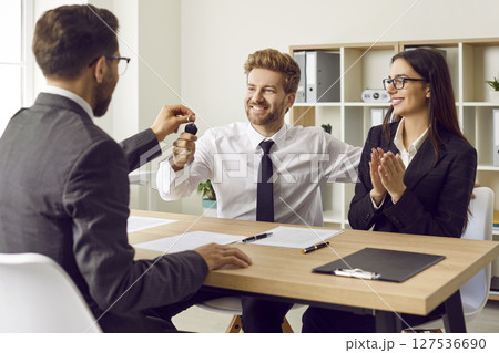 Young family couple purchase a car and take the key that the salesman gives them 127536690