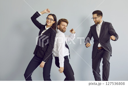 Funny business people dancing and celebrate success in business isolated on grey background. Funny business people dancing and celebrate success in business isolated on grey background. 127536808