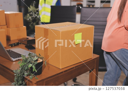 Startup SME small business entrepreneur of freelance Asian woman wearing apron using laptop and box to receive and review orders online to prepare to pack sell to customers, online sme business ideas. 127537038