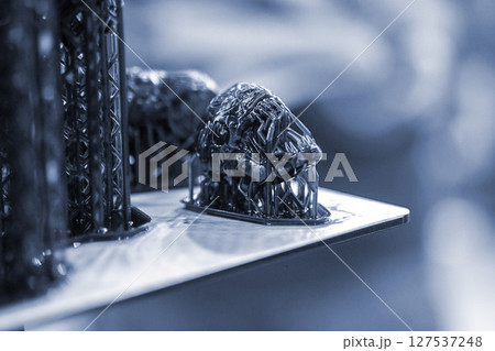An object printed on a 3D printer from hardened rubber close-up. Model black color created on a 3D printer from hardened rubber under influence of ultraviolet light. SLA 3D printing. Stereolithography 127537248