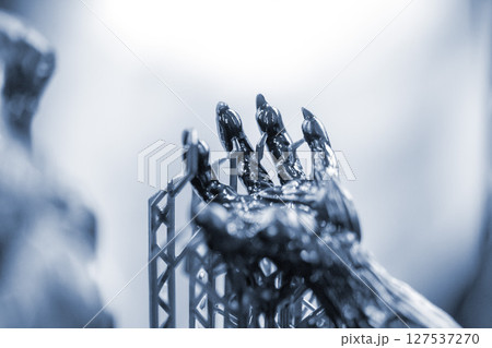 An object printed on a 3D printer from hardened rubber close-up. Model black color created on a 3D printer from hardened rubber under influence of ultraviolet light. SLA 3D printing. Stereolithography 127537270