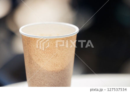 Warm coffee cup resting on a table in a cozy cafe ambiance during a leisurely afternoon 127537534