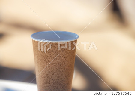 Enjoying a cozy moment with a warm cup of coffee in an inviting outdoor setting Enjoying a cozy moment with a warm cup of coffee in an inviting outdoor setting 127537540
