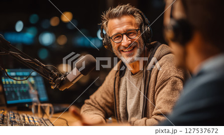 Smiling man engages with presenter during live discussion at studio 127537672