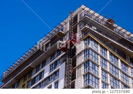 A building under construction with a blue sky behind it 127537890