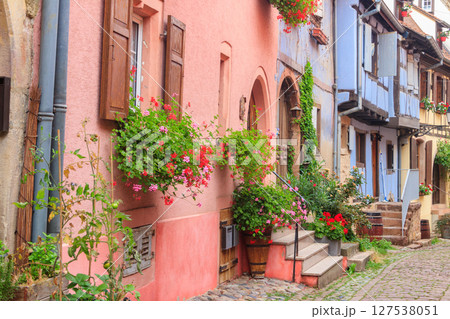 Street with picturesque colorful half-timbered houses in the medieval village of Eguisheim, Alsace, France. Village is ranked in the top 20 of Les Plus Beaux Villages de France. Alsace wine route 127538051