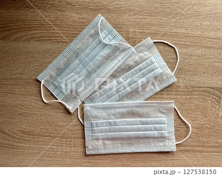 Three blue medical masks are on the table. High quality photo 127538150