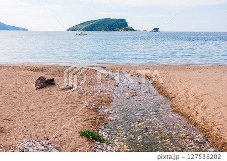 Island view and quiet shore in Montenegro. Coastal relaxation, vacation ambiance and summer leisure by the sea. 127538202