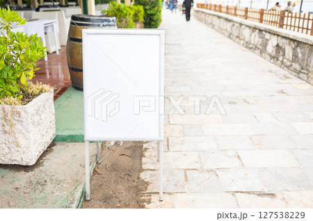 Empty blank white signboard by the seaside cafe, copy space. and mockup Coastal relaxation, vacation ambiance and summer leisure by the sea. 127538229
