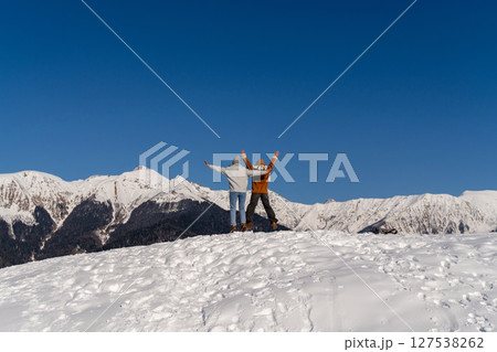 Couple Winter Mountains Triumph: Joyful Celebration Snowy Peak, Sunny Day Couple Winter Mountains Triumph: Joyful Celebration Snowy Peak, Sunny Day 127538262