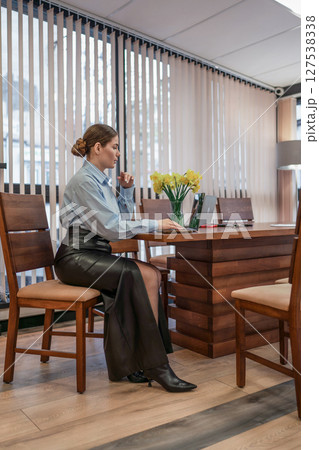Woman Laptop Office: Businesswoman works at desk in daytime office, considering project details. Woman Laptop Office: Businesswoman works at desk in daytime office, considering project details. 127538338