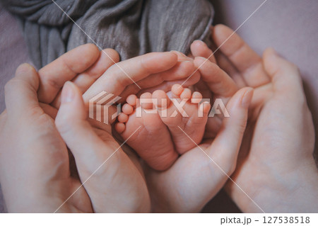 Mom's arms hug the baby. the legs of a newborn. the heels, the fingers of a baby, a child. Childbirth, maternity capital, artificial insemination, IVF, mortgage, family, love. High quality photo Mom's arms hug the baby. the legs of a newborn. the heels, the fingers of a baby, a child. Childbirth, maternity capital, artificial insemination, IVF, mortgage, family, love. High quality photo 127538518