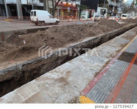 Cordoba, Argentina - May 08, 2025: Construction work. Laying underground utilities in the city center. Trench and soil dumps for laying utilities. 127539427