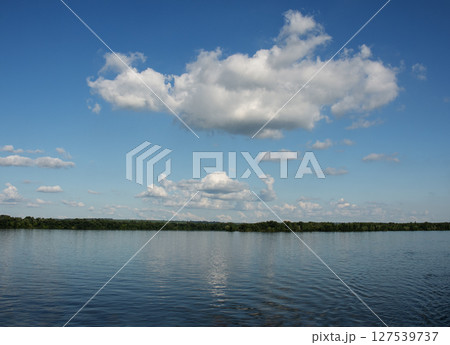 Panoramic view of Dnieper River bank. Reflection of the sky with clouds on the water surface. Panoramic view of Dnieper River bank. Reflection of the sky with clouds on the water surface. 127539737