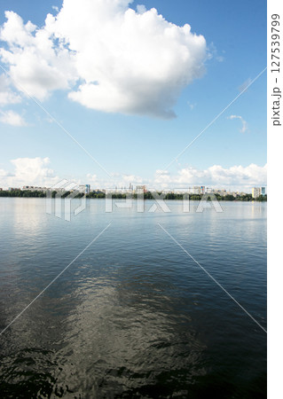 Panoramic view of left bank of Dnieper River. Ukraine. The city of Dnieper. Reflection of the sky with clouds on the water surface. 127539799