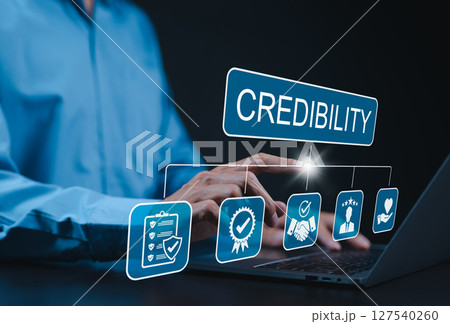 Credibility and trust in business concept. Businessman using laptop with icons credibility, trust, reputation, verification, integrity, reliable, authentic, commitment, regard, and quality assurance. 127540260