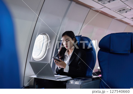 Beautiful Asian businesswoman working with laptop and mobile in aeroplane. working, travel, business concept 127540660