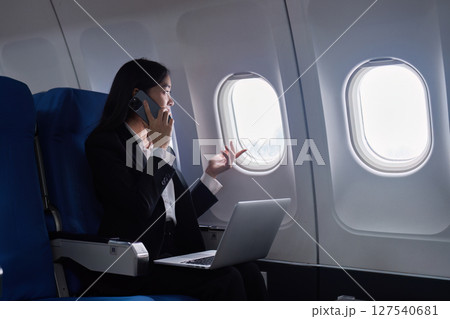 Beautiful Asian businesswoman working with laptop and mobile in aeroplane. working, travel, business concept 127540681