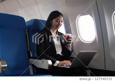 Beautiful Asian businesswoman working with laptop in aeroplane. working, travel, business concept 127540725