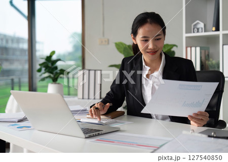 Businesswoman working with document and using calculator for checking finance report 127540850