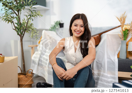 Smiling in a New Space. A woman poses happily in her decorated living room. Smiling in a New Space. A woman poses happily in her decorated living room. 127541013