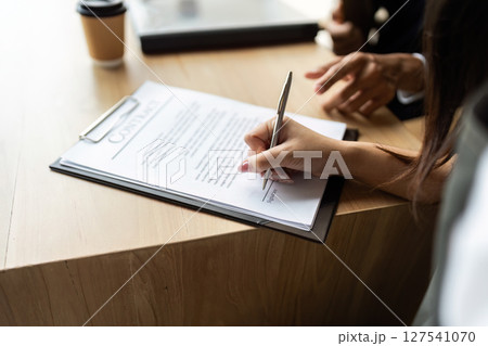Contract Signing and Agreement. Professional signing important documents at a desk. Contract Signing and Agreement. Professional signing important documents at a desk. 127541070