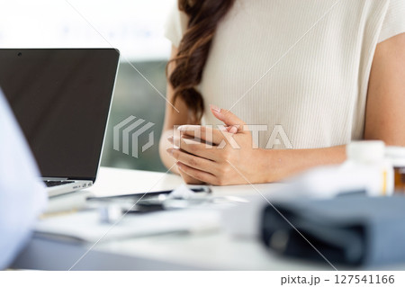 Patient in Consultation. Female patient with hands clasped waiting for medical advice. Patient in Consultation. Female patient with hands clasped waiting for medical advice. 127541166