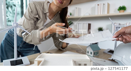 Collaborative Architectural Design. Female architect discussing plans with a colleague. Collaborative Architectural Design. Female architect discussing plans with a colleague. 127541177