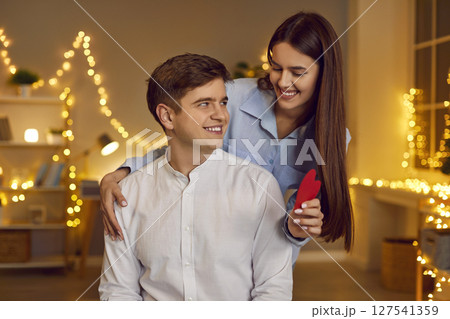 Girl Giving Boyfriend Red Heart On Valentine Day At Home Girl Giving Boyfriend Red Heart On Valentine Day At Home 127541359