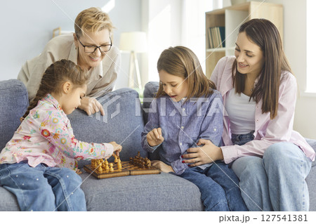 Positive Kids With Grandmother And Mother Playing Chess Positive Kids With Grandmother And Mother Playing Chess 127541381