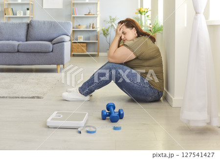 Portrait of depressed upset fat woman covering face with hands at home. Portrait of depressed upset fat woman covering face with hands at home. 127541427