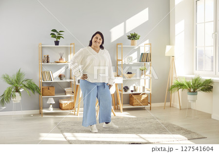 Portrait of a fat plus size brunette woman standing at home and smiling. 127541604