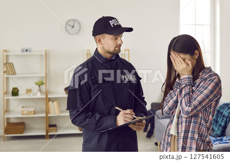 Weeping woman talking to police officer after breaking into house Weeping woman talking to police officer after breaking into house 127541605