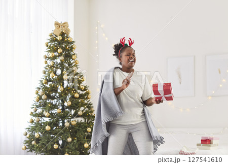 African American Woman Celebrating New Year Or Christmas By Dancing And Singing African American Woman Celebrating New Year Or Christmas By Dancing And Singing 127541610