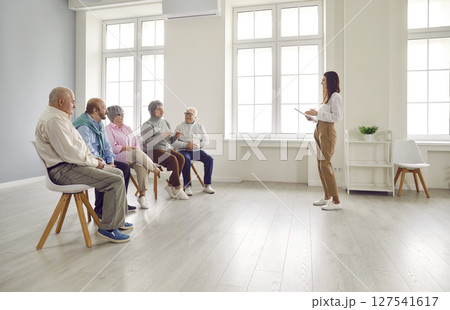 Psychologist checks mental health of elderly people during group therapy session. 127541617