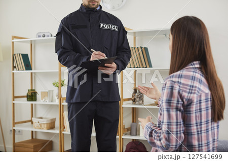 Woman talking to policeman after breaking into house Woman talking to policeman after breaking into house 127541699