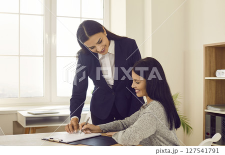 Businesswoman signing contract at business meeting in office Businesswoman signing contract at business meeting in office 127541791