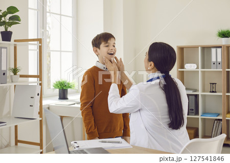 Woman doctor endocrinologist or otolaryngologist is examining her child patient Woman doctor endocrinologist or otolaryngologist is examining her child patient 127541846