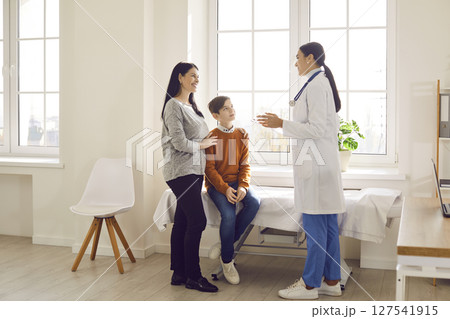 Portrait of a little boy patient with his mother talking with paediatrician doctor in clinic. Portrait of a little boy patient with his mother talking with paediatrician doctor in clinic. 127541915