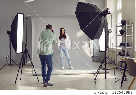 Beautiful model posing for male photographer in studio 127541992