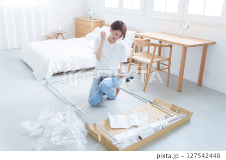 家具の組み立てを頑張る女性 127542448