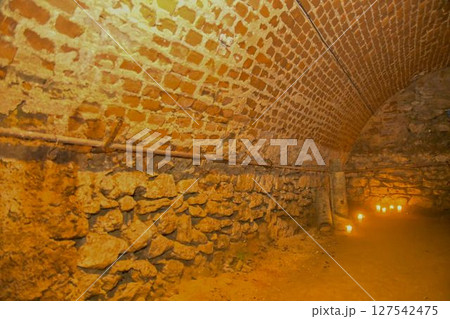 A view of old corridors lit by candles. Old cellar spaces lit by candles. The concept of romance and old times 127542475