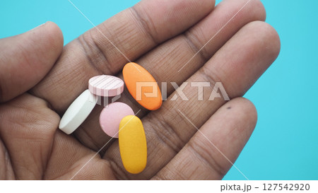 Colorful tablets held in a hand against a bright background Colorful tablets held in a hand against a bright background 127542920